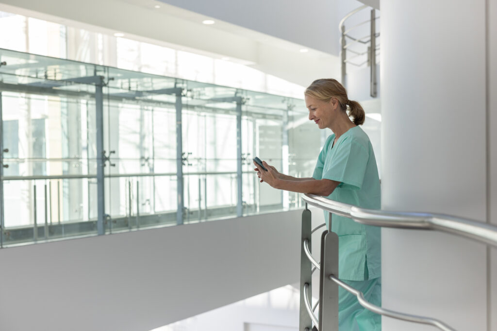 Healthcare professional in a modern hospital looking at smartphone